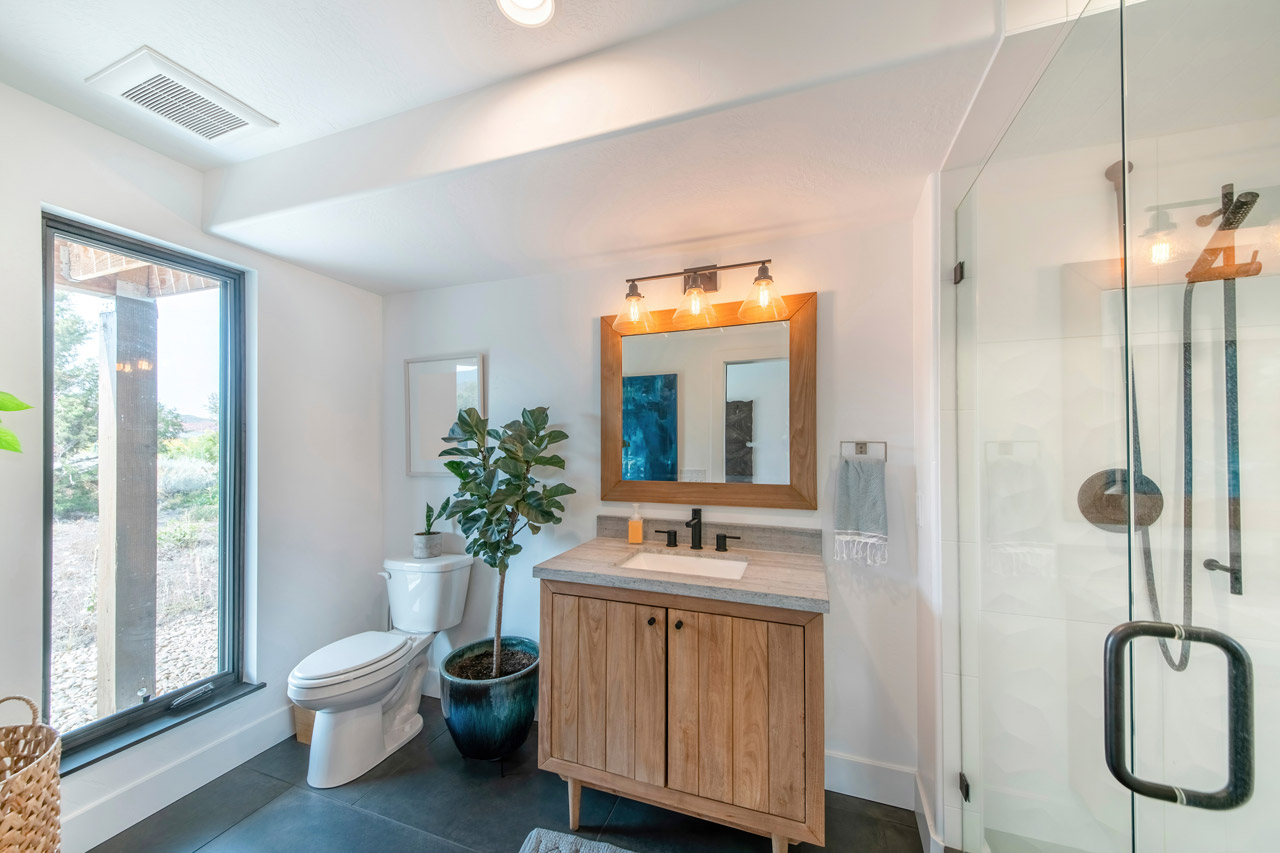 A modern bathroom with a large window and an exhaust fan