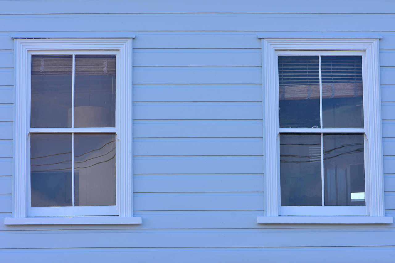 newly repaired wood siding on home near windows