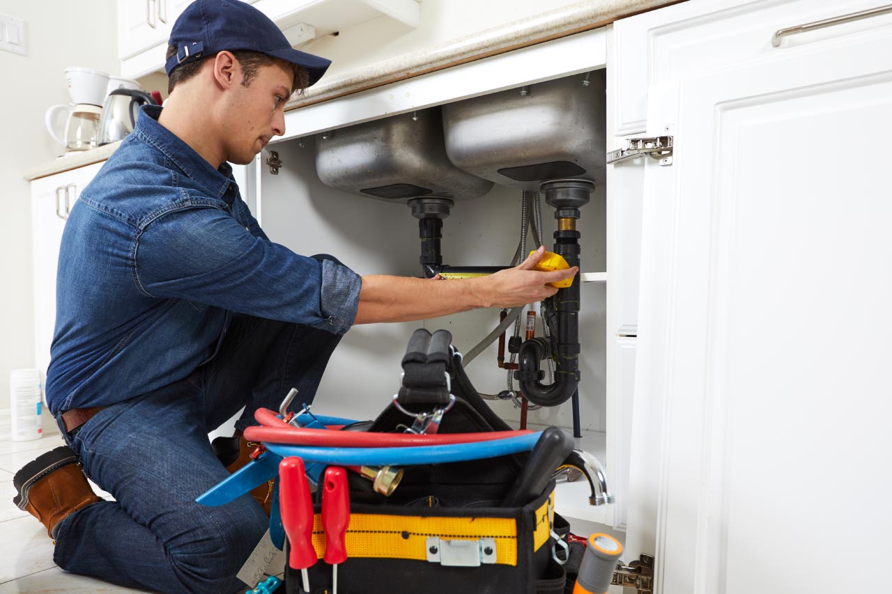 A plumber checking pipes