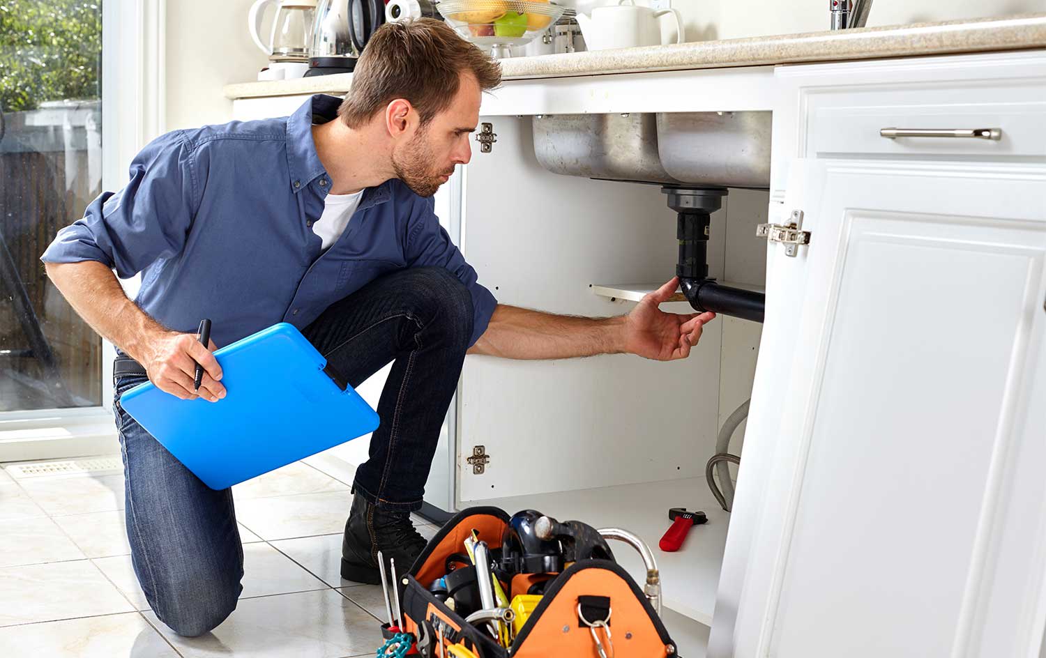 Plumber checking kitchen's plumbing