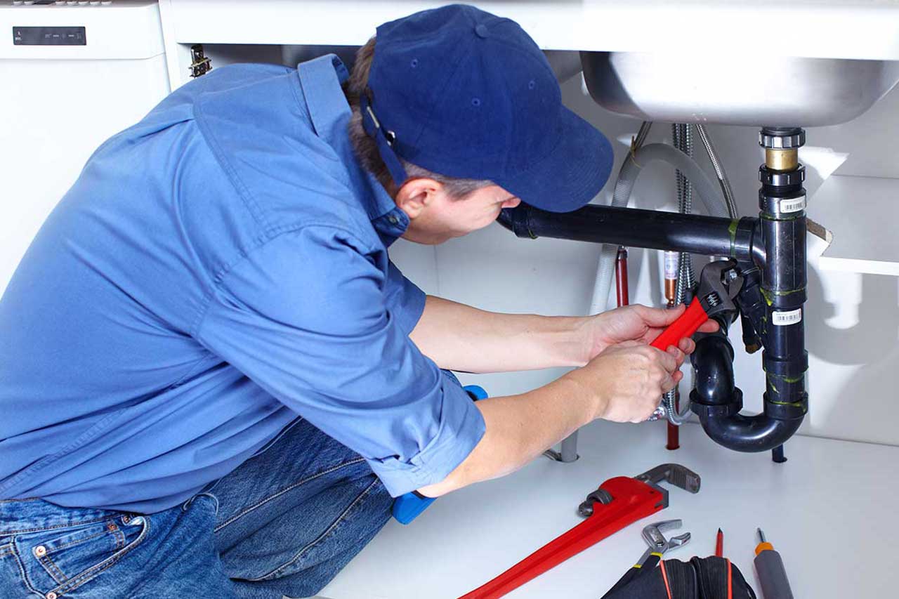 Plumber fixing bathroom sink pipes