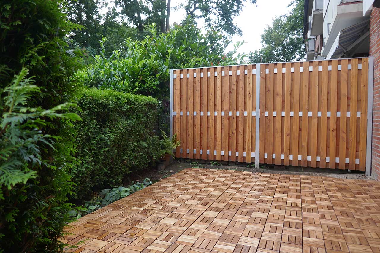 Patio with wooden fence and bushes